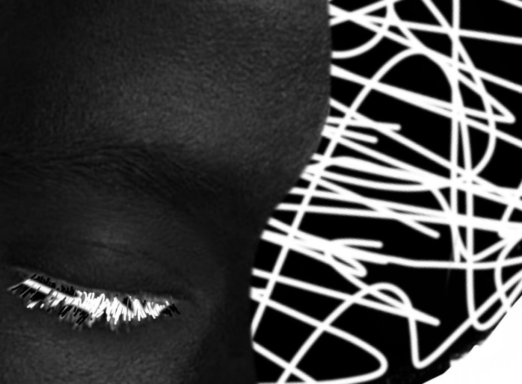 Visage noir aux yeux clos, cils blancs, face à un enchevêtrement de tracés blancs sur fond noir.